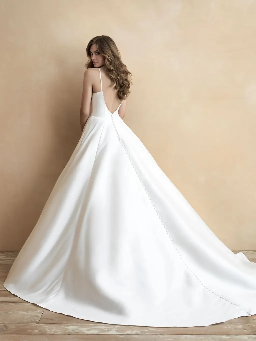 Model is wearing a minimalist ball gown featuring silky fabric and asymmetrical ruching for a modern wrap effect.
