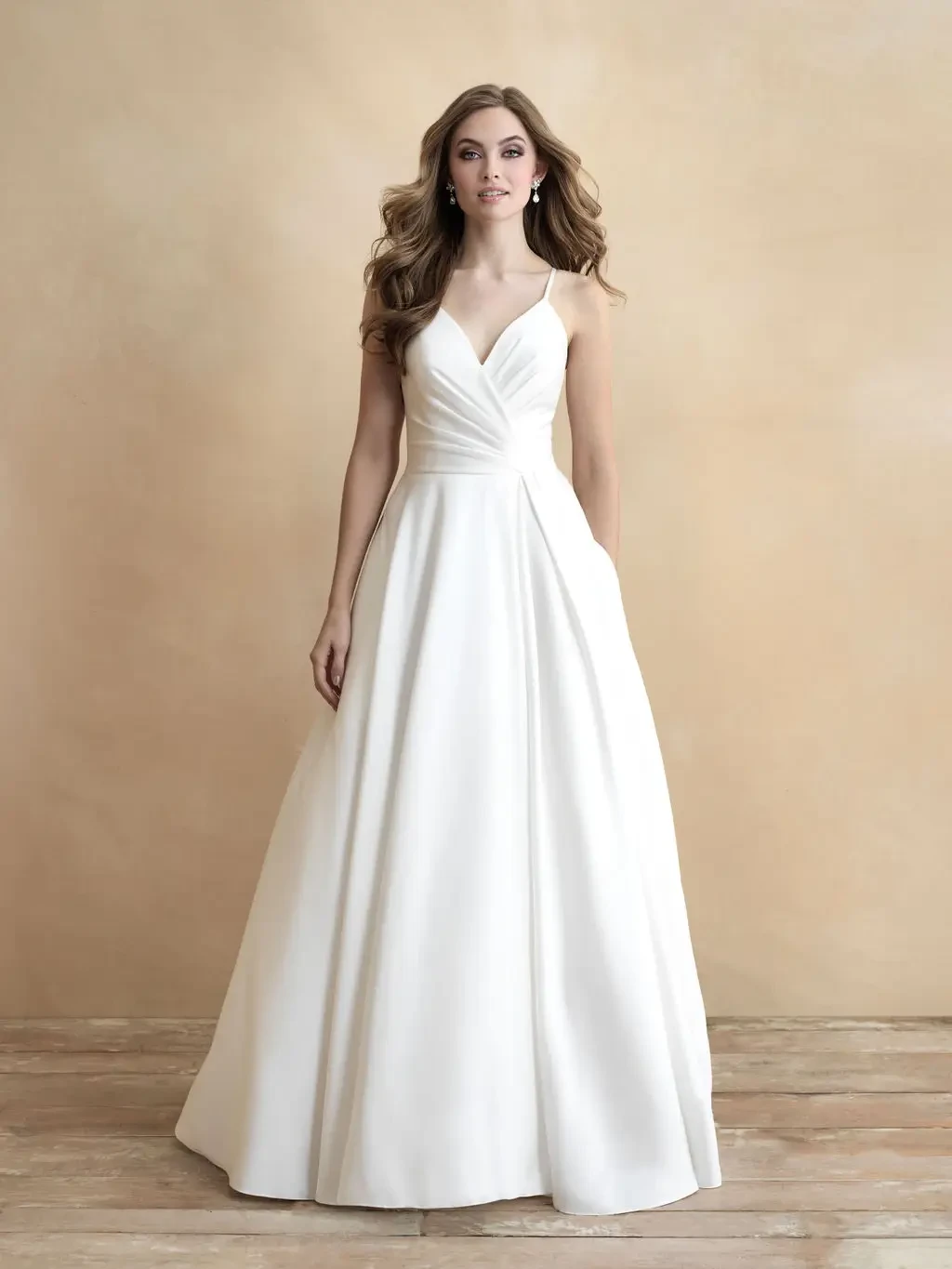 Model is wearing a minimalist ball gown featuring silky fabric and asymmetrical ruching for a modern wrap effect.
