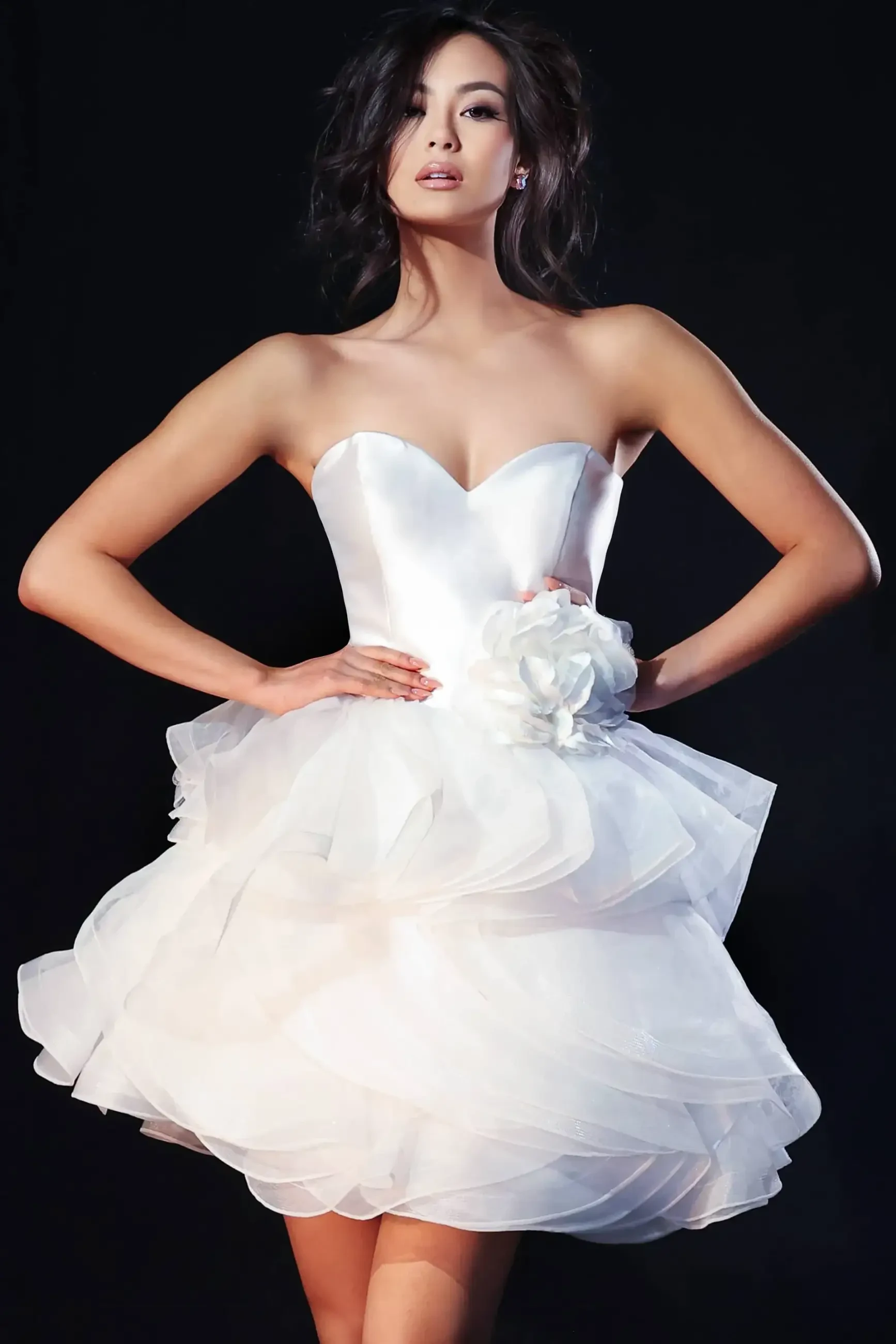 model is wearing a strapless white mini prom dress