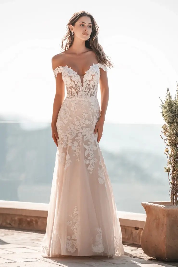Model is wearing a sparkly wedding dress with off the shoulder sleeves by allure bridals