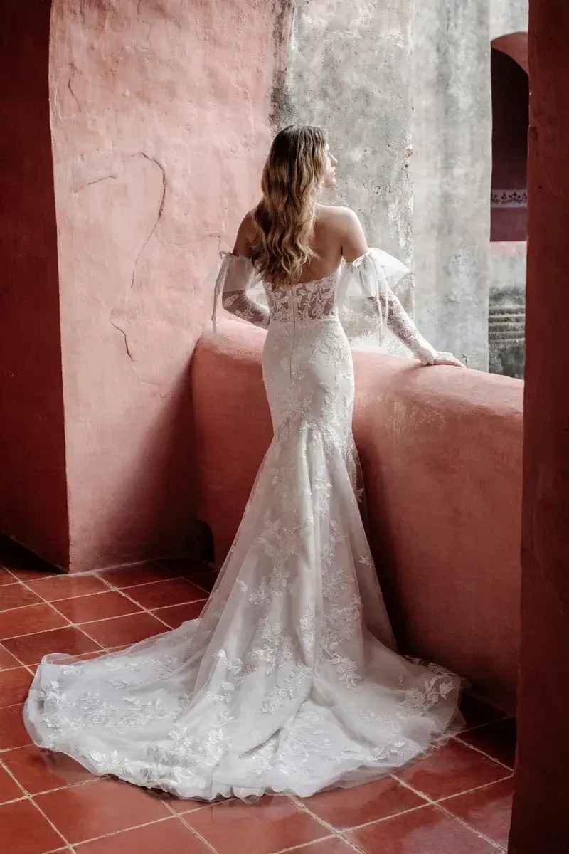 Model is wearing a wedding dress with detachable tulle sleeves by abella