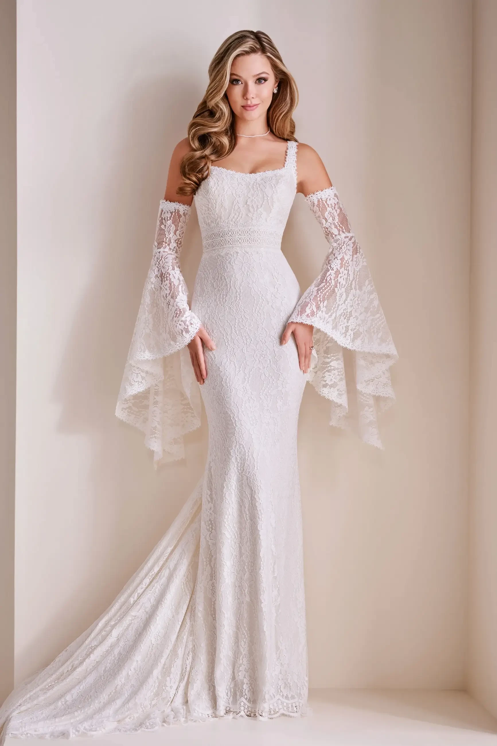 Model is wearing a lace mermaid wedding gown with a scoop neck, separate lace sleeves, and an 80-inch train.\