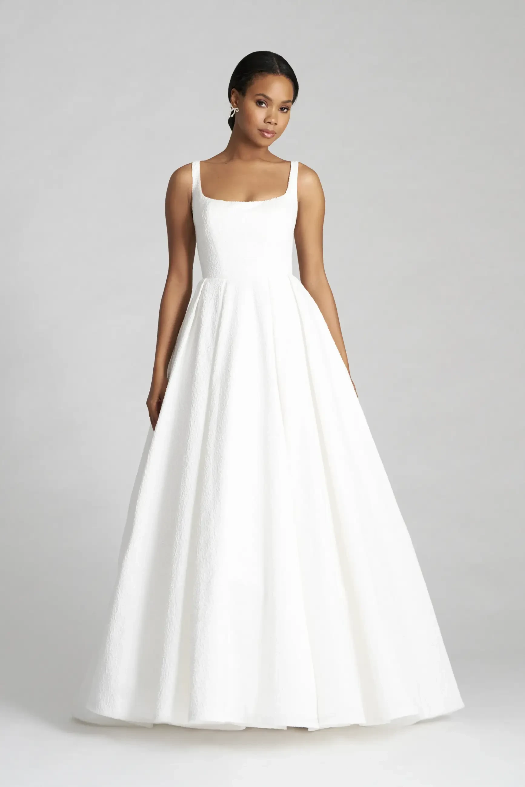 model is wearing a sleeveless ball gown wedding dress
