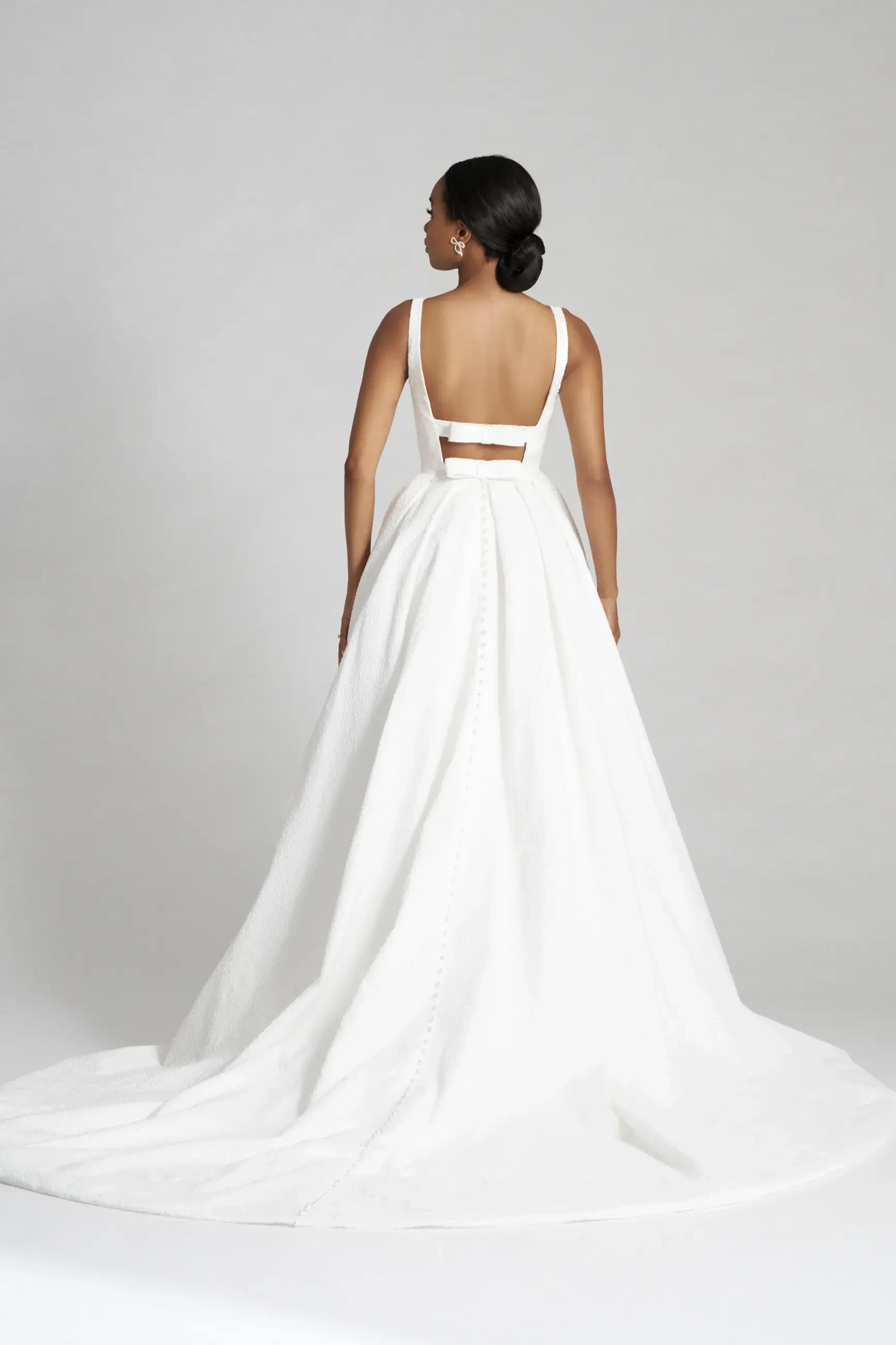 model is wearing a sleeveless ball gown wedding dress